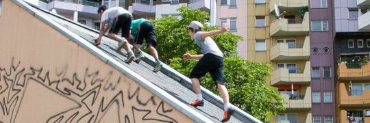 Jungs laufen Parkour auf einem Dach