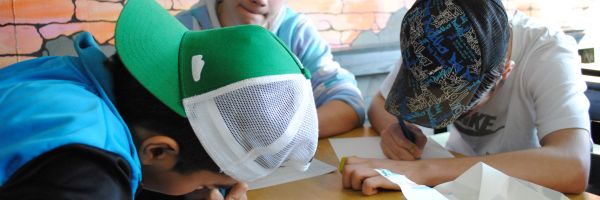 Drei Jugendliche beim Schreiben